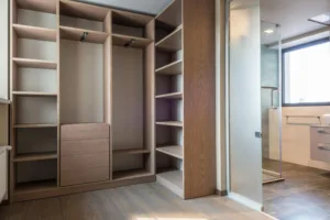 Spacious walk-in closet with wooden shelves and minimalist style.