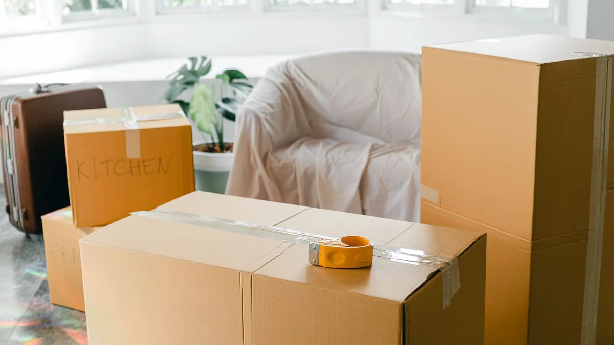 Verpackte Möbelkartons und sortierte Kleinteile vor der Montage